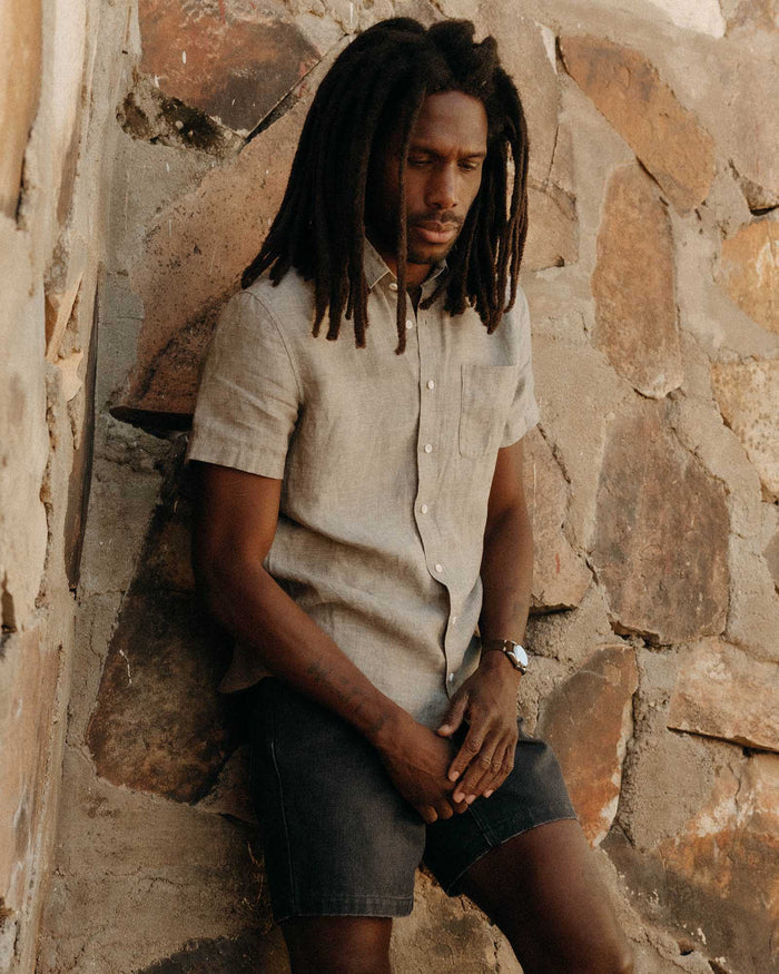 fit model leaning against the wall wearing The Short Sleeve California in Morel Hemp