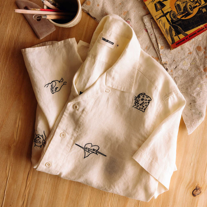 editorial flatlay of The Short Sleeve Davis Shirt in Embroidered Natural on the ground of a studio