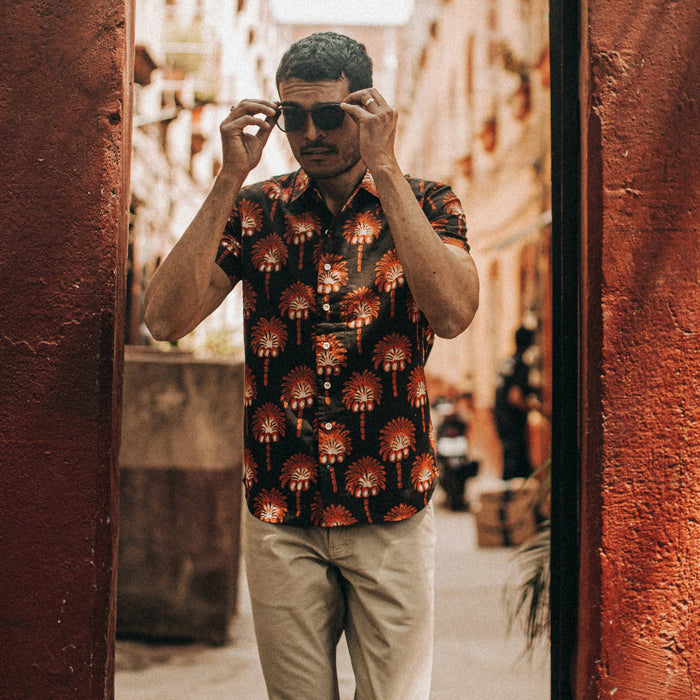 fit model wearing The Short Sleeve Hawthorne in Mirage Palm, touching sunglasses