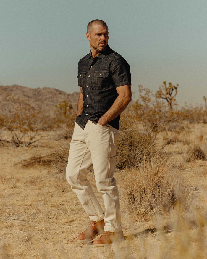 fit model with his hand in his pockets wearing The Short Sleeve Mechanic Shirt in Rinsed Indigo Denim