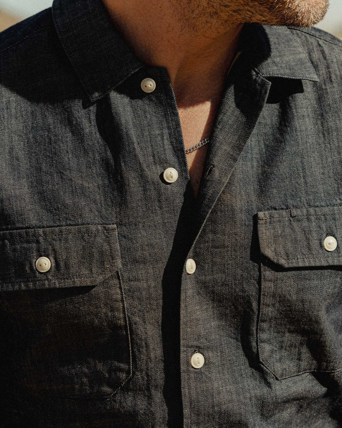 fit model showing off the pockets on The Short Sleeve Mechanic Shirt in Rinsed Indigo Denim