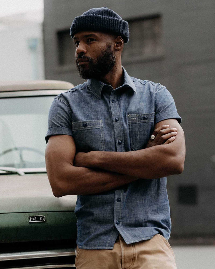 fit model with his arms crossed wearing The Short Sleeve Utility Shirt in Indigo Selvedge Chambray