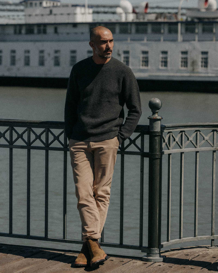 fit model leaning against the wall wearing The Sidecountry Crew in Heather Graphite Merino Waffle