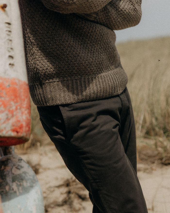 fit model standing in a field wearing The Slim Foundation Pant in Organic Faded Black