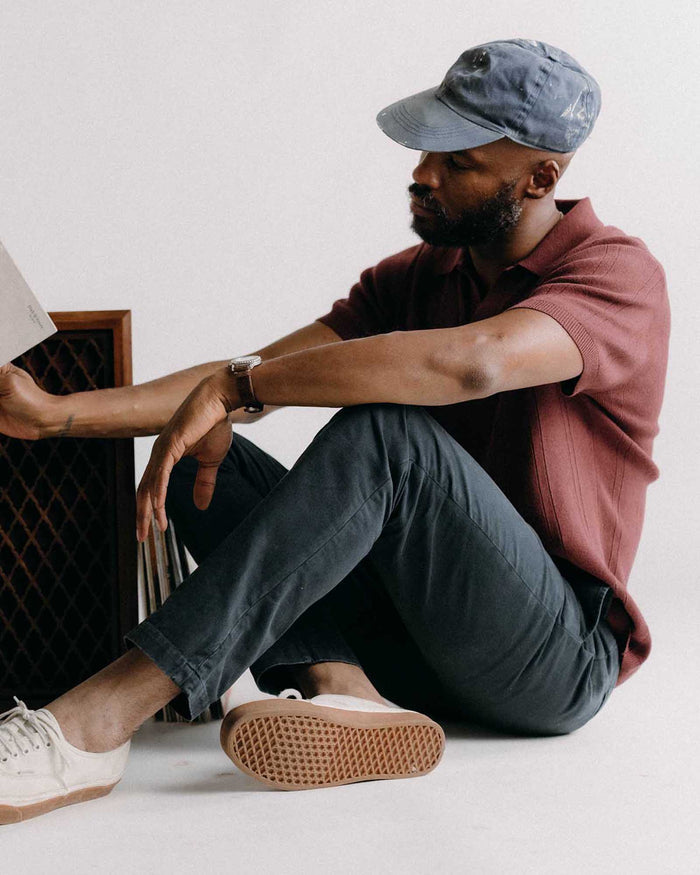 fit model sitting wearing The Slim Foundation Pant in Organic Navy