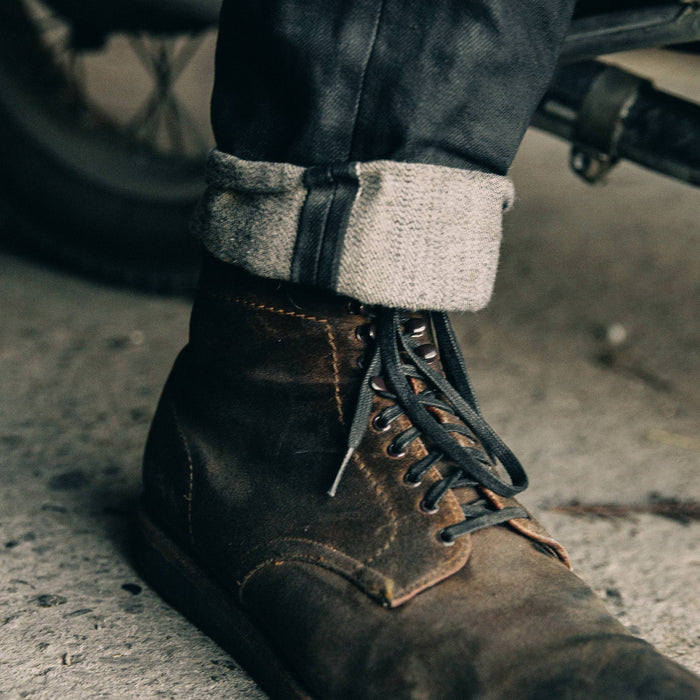fit model wearing The Slim Jean in Black Over-dye Selvage, cuffed shot over boot