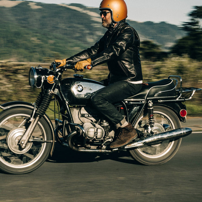fit model wearing The Slim Jean in Black Over-dye Selvage, riding bike