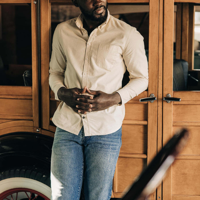 fit model leaning against a car wearing The Slim Jean in Fletcher Wash Organic Selvage