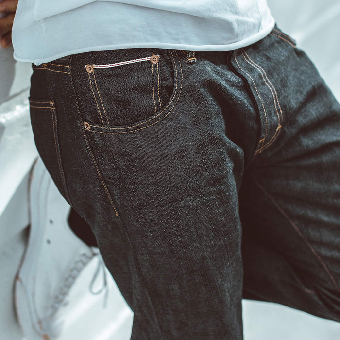 Fit model against white wall in light weight denim