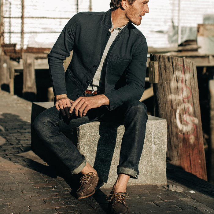 fit model wearing The Slim Jean in Organic Selvage, sitting near dock