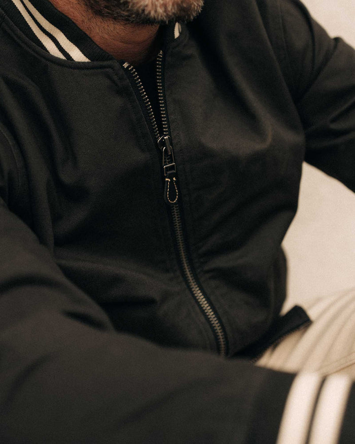 fit model showing off the zipper on The Speedway Bomber in Organic Faded Black Twill