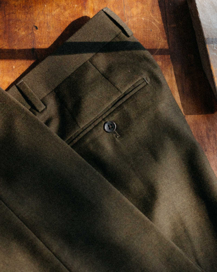editorial flatlay of The Stevens Trouser in Black Olive Wool Flannel