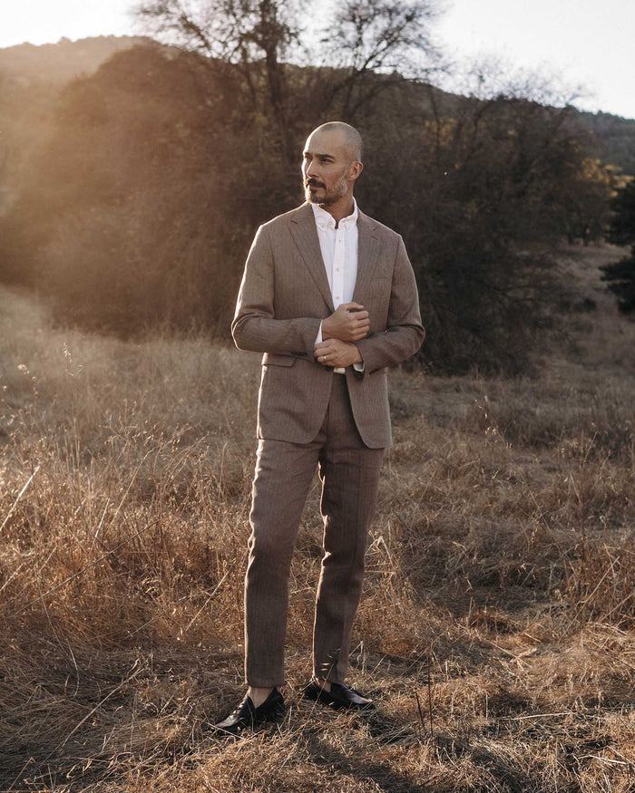 fit model posing in The Stevens Trouser in Coffee Linen Herringbone