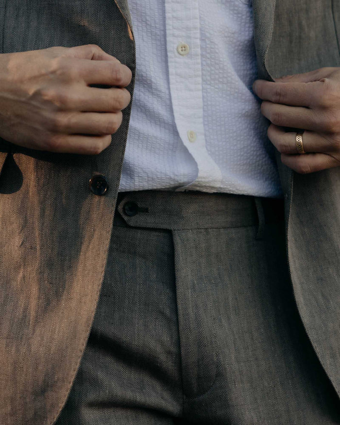fit model posing in The Stevens Trouser in Coffee Linen Herringbone