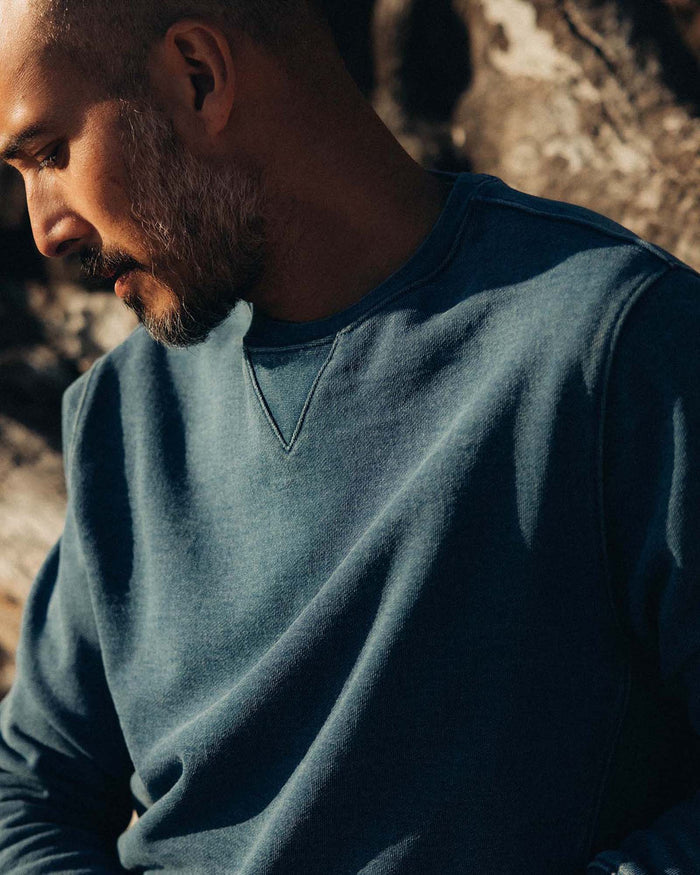 fit model leaning against a tree wearing The Apres Crew in Washed Indigo Terry