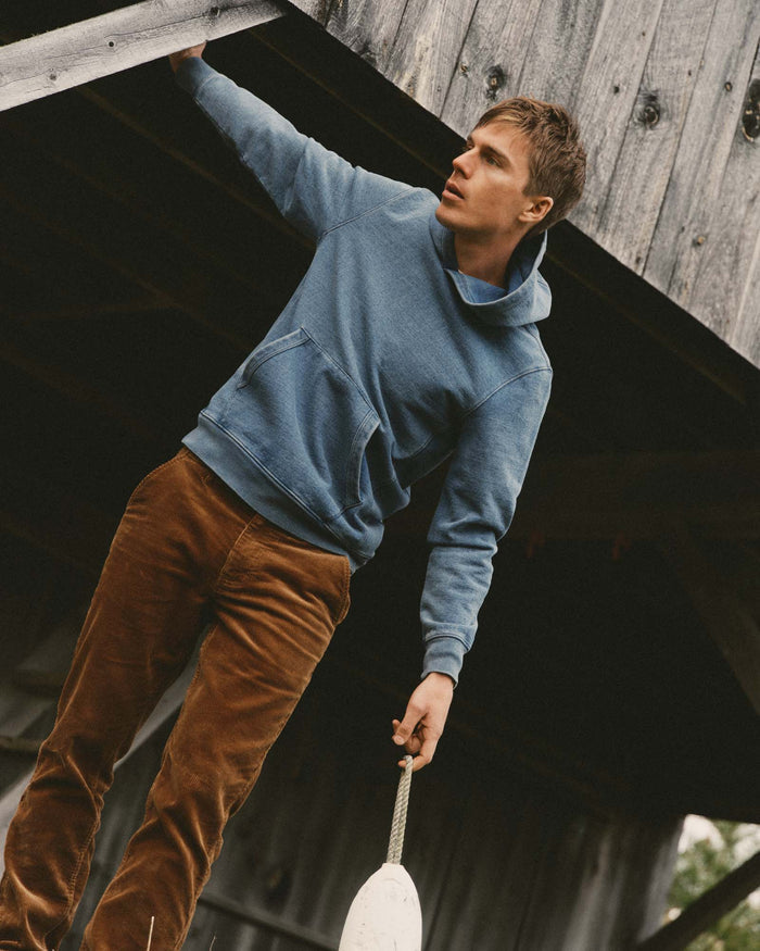 fit model posing wearing The Apres Hoodie in Washed Indigo Terry