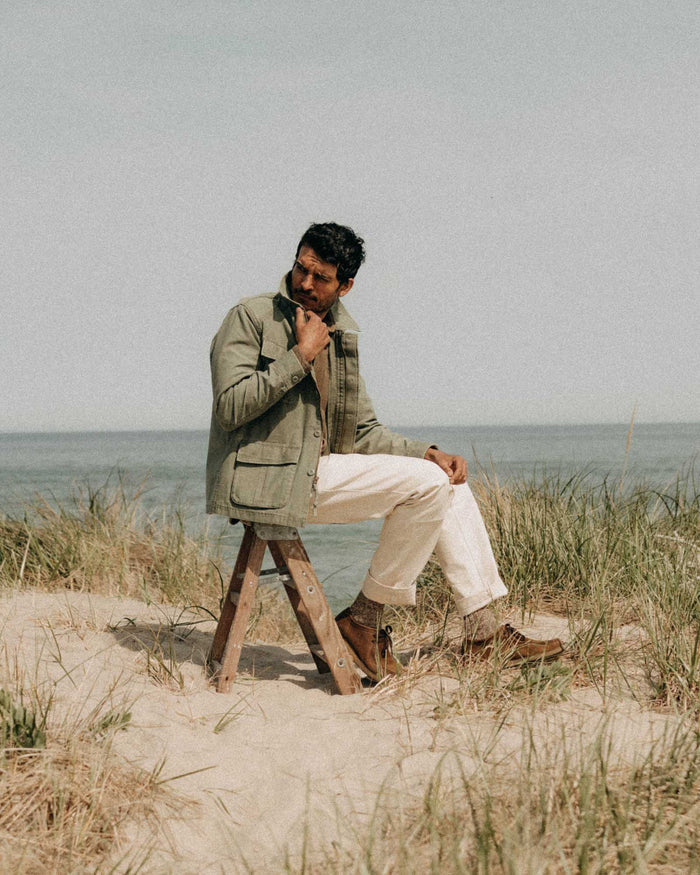 fit model sitting wearing The Surplus Jacket in Field Olive Reverse Sateen