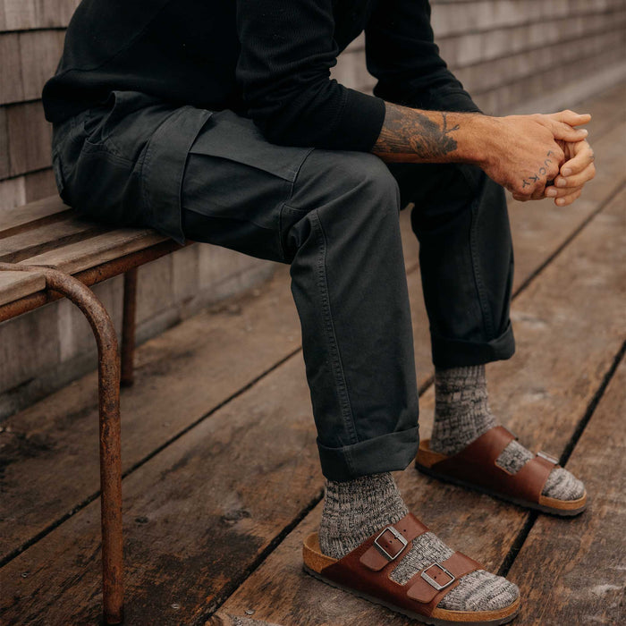 fit model sitting wearing The Tommie Pant in Faded Black