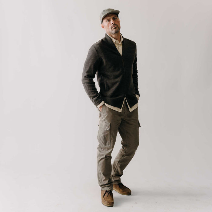 fit model with his hands in his pockets wearing The Tommie Pant in Fatigue Olive