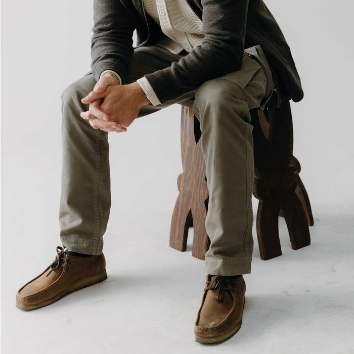 fit model sitting wearing The Tommie Pant in Fatigue Olive