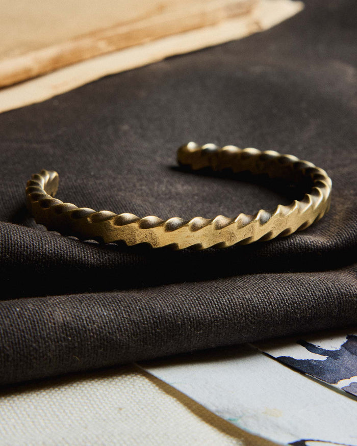 editorial image of The Twisted Cuff in Brass on a piece of fabric