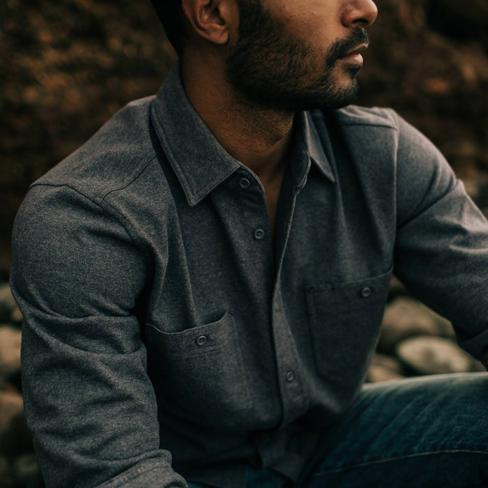 fit model sitting down while wearing The Utility Shirt in Dark Charcoal Heavy Bag