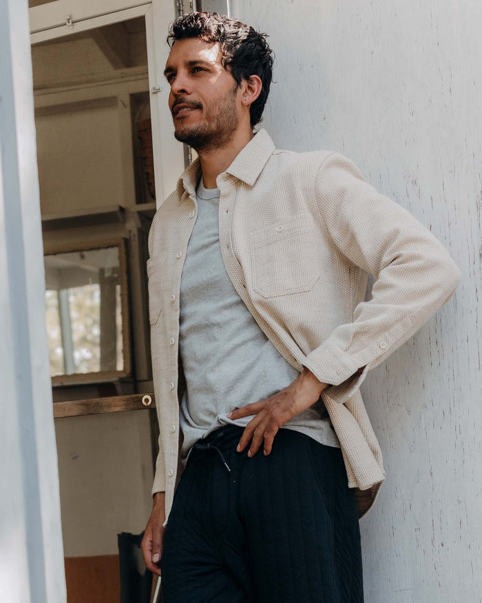fit model leaning against the wall wearing The Utility Shirt in Natural Sashiko
