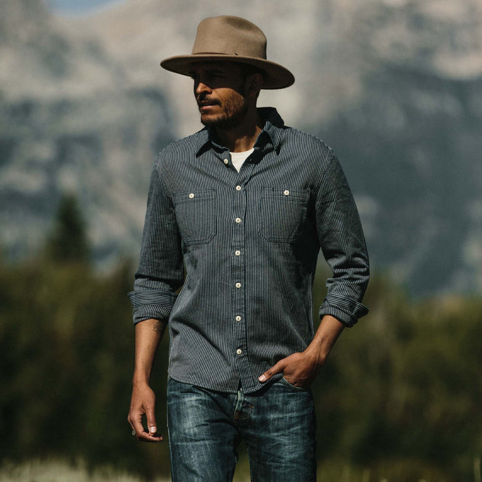 Fit model wearing The Utility Shirt in Roped Indigo in front of a Wyoming mountainscape