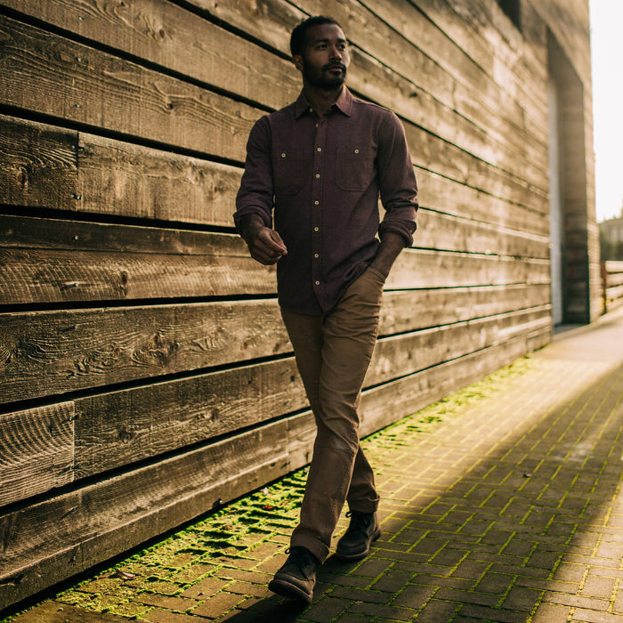 fit model walking down mossy path of The Utility Shirt in Russet Heavy Bag