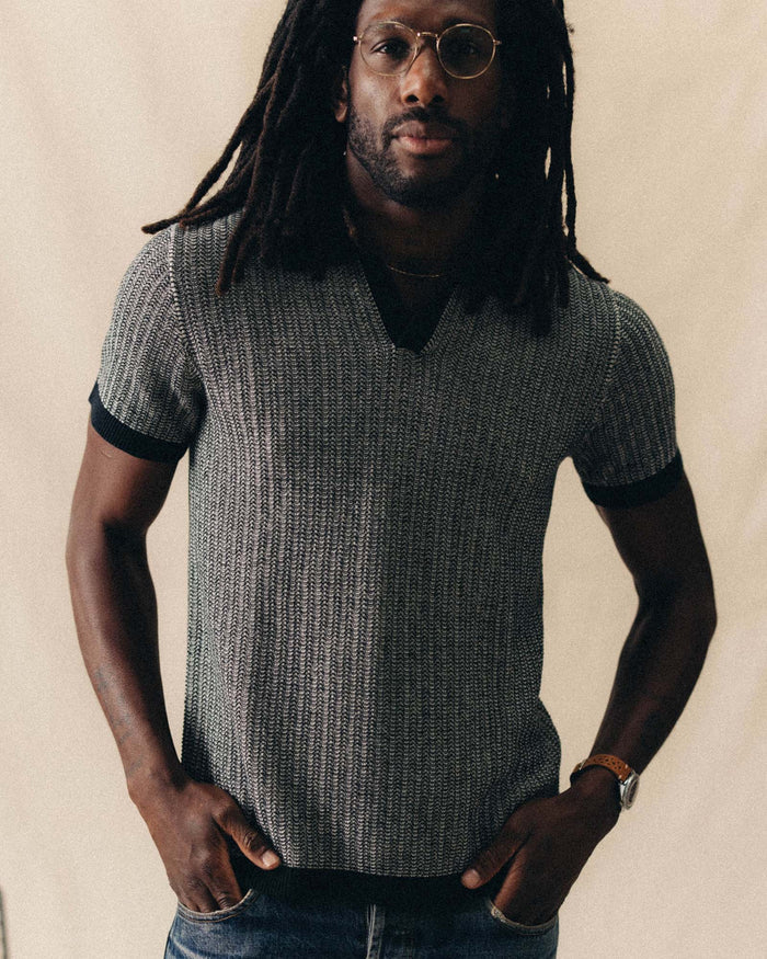 fit model with his hands in his pockets wearing The Valencia Sweater Polo in Coal Scallop
