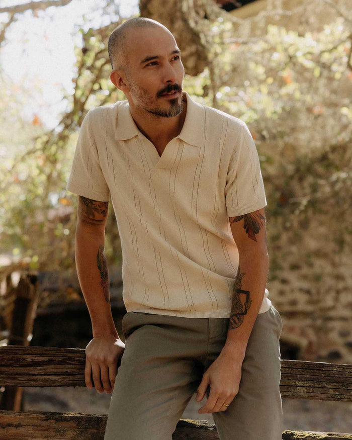 fit model sitting wearing The Valencia Sweater Polo in Heather Oat Rib