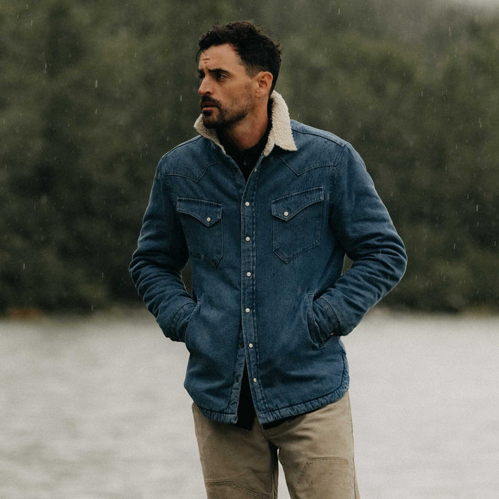fit model leaning against the wall wearing The Western Shirt Jacket in Washed Indigo