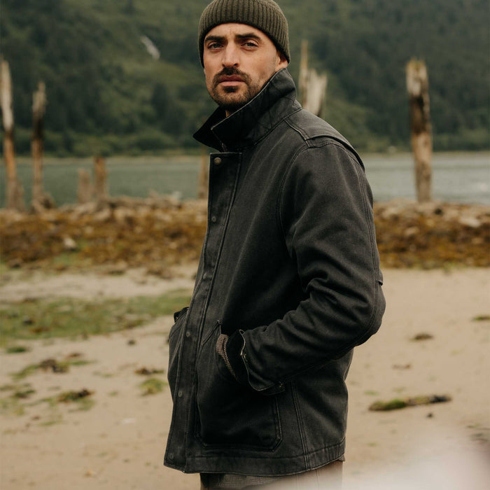fit model with his hands in his pockets wearing The Workhorse Jacket in Coal Chipped Canvas