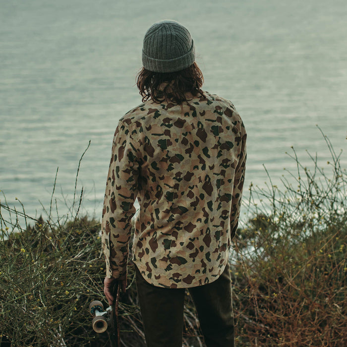 Fit model next to ocean wearing Yosemite Shirt in Camo