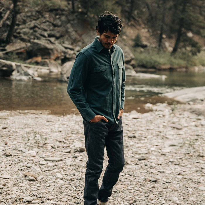 fit model wearing The Yosemite Shirt in Deep Ocean—walking near creek