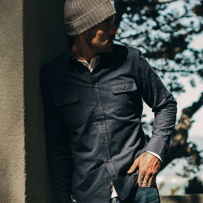 fit model wearing The Yosemite Shirt in Midnight, leaning against wall