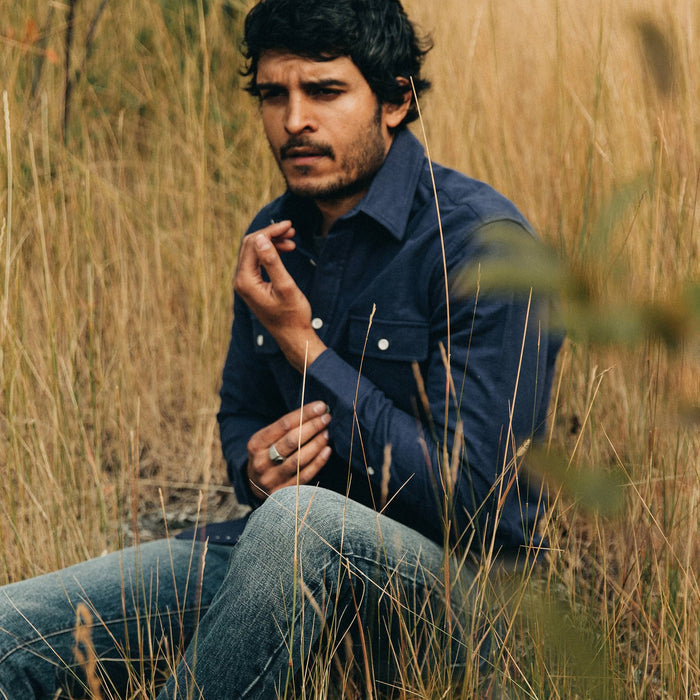 fit model wearing The Yosemite Shirt in Navy, sitting in field