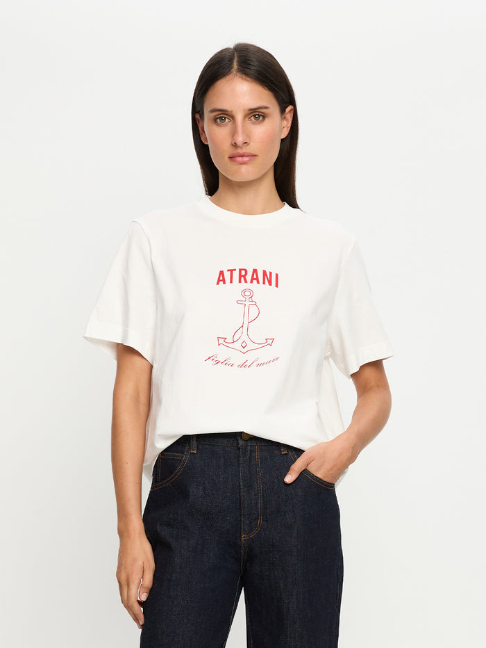Woman wearing a white t-shirt with red text and anchor graphic on a plain background