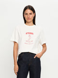 Woman wearing a white t-shirt with red text and anchor graphic on a plain background