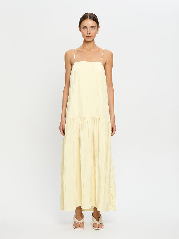Woman wearing a light yellow dress on a white background