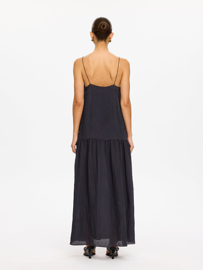 KIVARI Umi Maxi Dress in Charcoal – back view of model wearing women's charcoal spaghetti strap tiered maxi dress